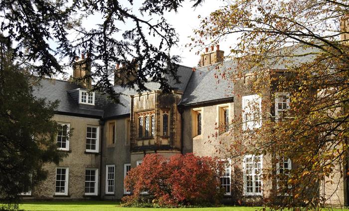 The exterior of Old Bishop's Palace surrounded by trees and shrubs